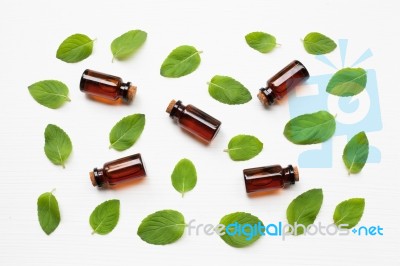 Mint Essential Oil In A Glass Bottle With Leaves On White Backgr… Stock Photo