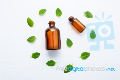 Mint Essential Oil In A Glass Bottle With Leaves On White Backgr… Stock Photo