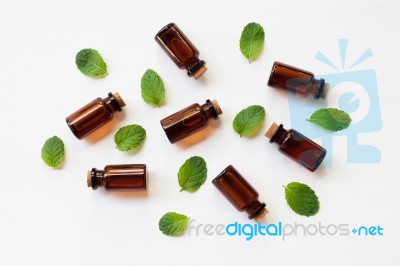 Mint Essential Oil In A Glass Bottle With Leaves On White Backgr… Stock Photo