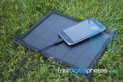 Mobile Phone Charging With Solar Energy - Charger Stock Photo