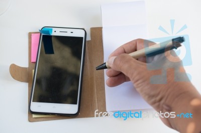Mobile Phone Notebook And Pen On White Background Stock Photo