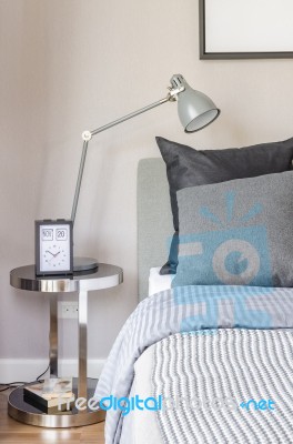 Modern Grey Lamp With Alarm Clock On Side Table In Bedroom Stock Photo