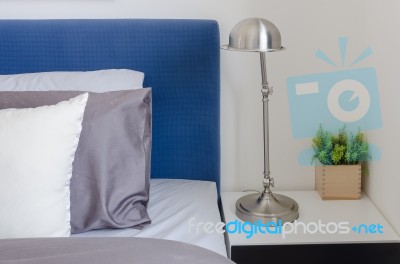 Modern Lamp On White Table In Bedroom Stock Photo