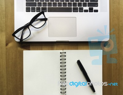 Modern Laptop With Paper Note Book With Pen And Glasses On Wood Stock Photo
