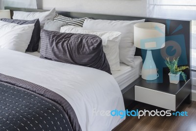 Modern White Lamp On Black Table In Bedroom Stock Photo