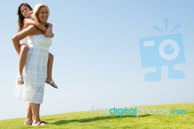 mom Giving Piggyback Ride Stock Photo