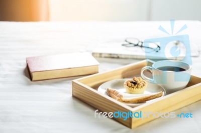 Morning Coffee Bread And Book Or Newspaper On The Bed Stock Photo