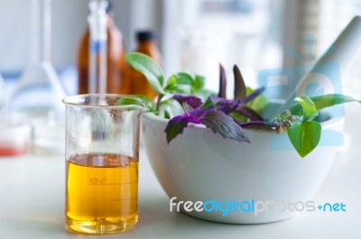 Mortar And Pestle With Herbs With A Glass Of Alternative Fuel Stock Photo
