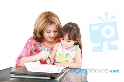 Mother And Daughter Doing Homework At Home Stock Photo