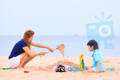 Mother And Sons Are Playing On Tropical Beach Stock Photo