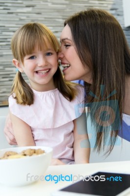Mother Giving A Kiss To His Daughter On The Cheek Stock Photo