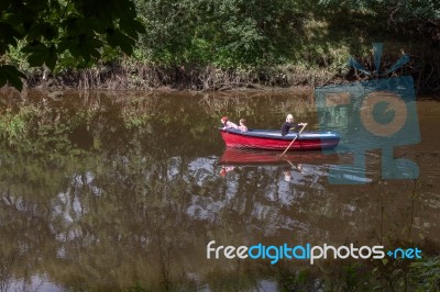Mother Rowing Her Children Along The River Coquet In Warkworth Stock Photo