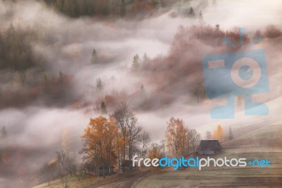 Mountain Village In Clouds Of Fog And Smoke In The Autumn Mornin… Stock Photo