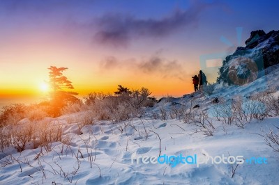 Mountaineer Stands On The Peak In Winter,deogyusan National Park In South Korea And Take Photo With Camera To Sunrise. Beautiful Moment The Miracle Of Nature Stock Photo