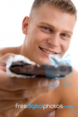 Muscular Man Offering Chocolate Stock Photo