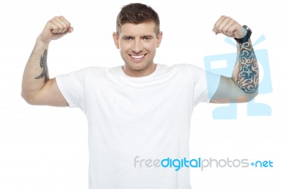 Muscular Young Man Showing Biceps Stock Photo