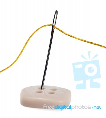 Needle With Thread Sews On Button Stock Photo