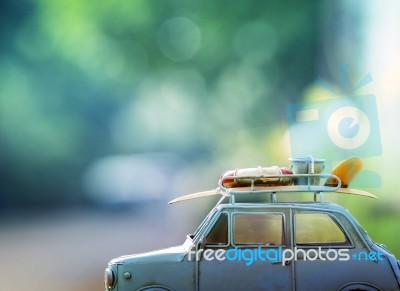 Old Classic Retro Car With Surf Board And Beach  Tool On Roof Against Beautiful Blur Background For Vacation Traveling Theme Stock Photo