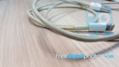 Old Smart Phone Charger Wire On Laminate Floor Stock Photo