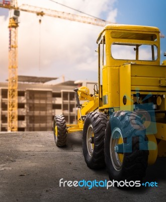 Old Yellow Motor Grader On The Road Stock Photo