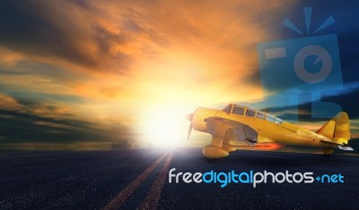 Old Yellow Propeller Plane On Airport Runway With Sunset Sky Background Stock Photo