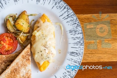 Omelet With Potato, Tomatoes Parsley And Feta Cheese And Bread In White Plate On Wooden Table Stock Photo