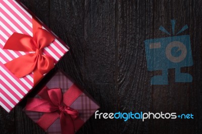 One Gift Box With An Red Big Ribbon On Old Wooden Dark Brown Bac… Stock Photo