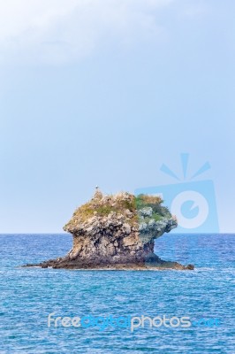 One Outstanding Rock Rising From Sea Level Stock Photo