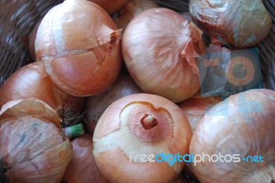 Onions In A Braided Brown Basket Stock Photo