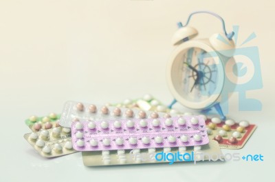 Oral Contraceptive Pills With Alarm Clock Background Stock Photo