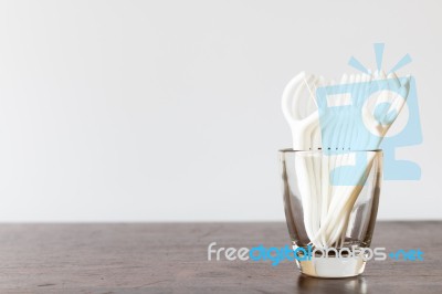 Oral Device : Dental Floss In Glass On Wooden Background Stock Photo