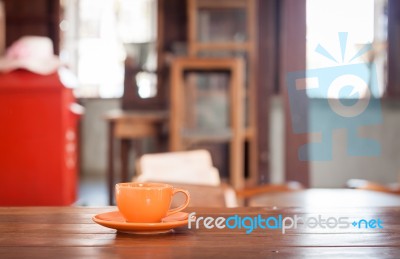 Orange Coffee Cup On Wooden Table Stock Photo