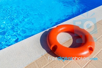 Orange Life Buoy Lying At Swimming Pool Stock Photo