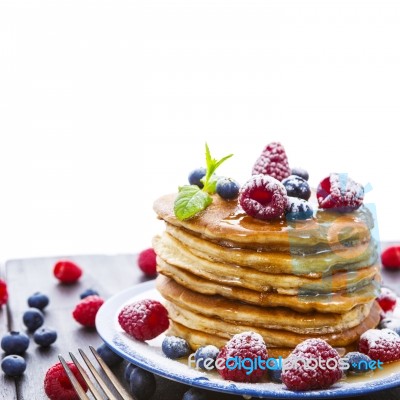 Pancakes With Honey And Berries On White Background Stock Photo