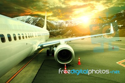 Pasenger Plane Parking On Airport Runnway Against Beautiful Sun Rising Sky Use For Traveling Buisiness And Air Transportation Theme Stock Photo