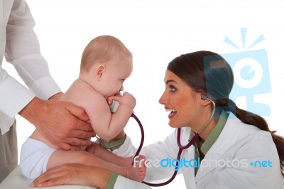 Pediatrician Examining Baby Boy Being Held By Father Stock Photo