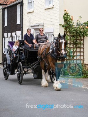 People Enjoying A Horse And Carriage Ride Through Southwold Stock Photo