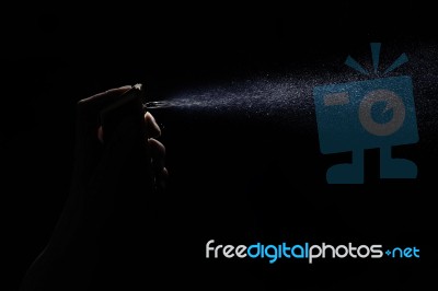 Perfume In Woman's Hand On Black Background Stock Photo
