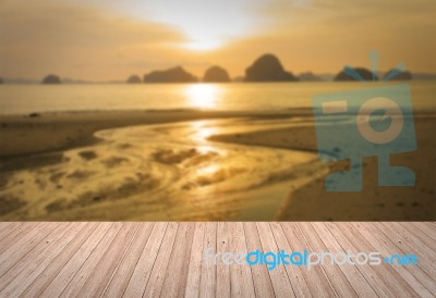 Perspective Of Wooden Terrace Against Sunset Beach Blurred Background Stock Photo