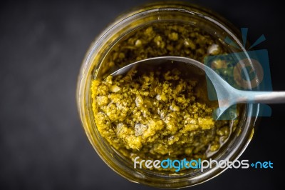 Pesto Sauce In The Glass Jar With Spoon Top View Stock Photo