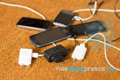 Phone Chargers On The Floor Stock Photo