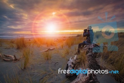 Photographer Taking A Sunset Photo On Sea Beach Stock Photo