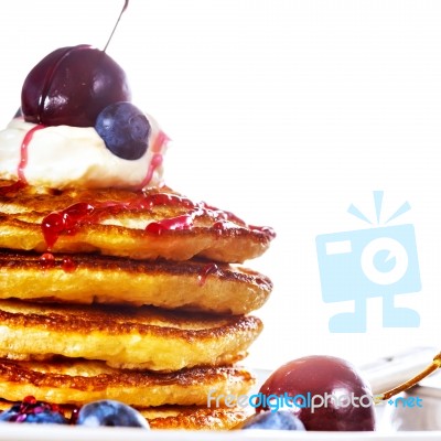 Pile Of Pancakes With Blueberries, Cherries And Sour Cream Stock Photo
