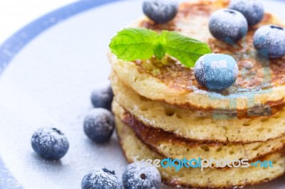 Pile Of Pancakes With Blueberries Sprinkled With Icing Sugar Stock Photo