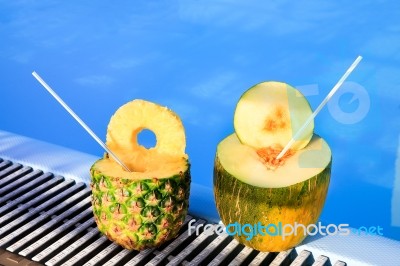 Pineapple And Melon Fruit With Straws At Swimming Pool Stock Photo