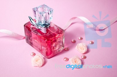 Pink Aromatic Perfume With And Pearls And Roses On Pink Background Stock Photo