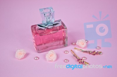 Pink Aromatic Perfume With Hairpins And Pink Pearls On Pink Background Stock Photo