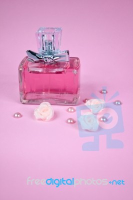 Pink Aromatic Perfume With Pink Pearls With Pink Textile Roses On Pink Background Stock Photo