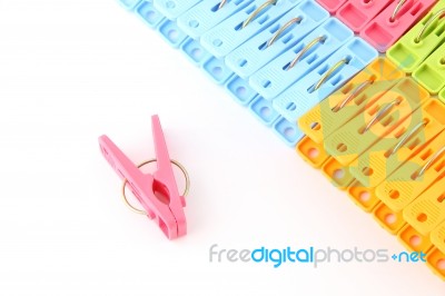 Pink Peg In Front Of Pegs Row From Upper On White Background Stock Photo