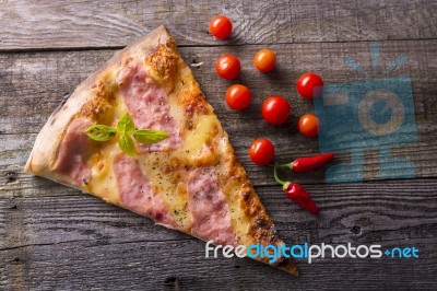 Pizza Cut On Wooden Table, Cherry Tomato And Hot Peppers Stock Photo